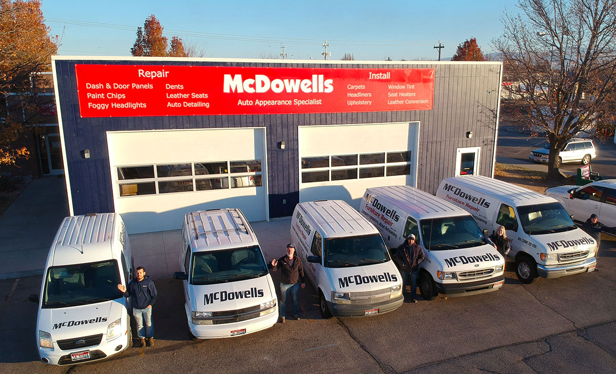 The crew's in front, waving and standing by their trucks. The McDowells building is behind them.