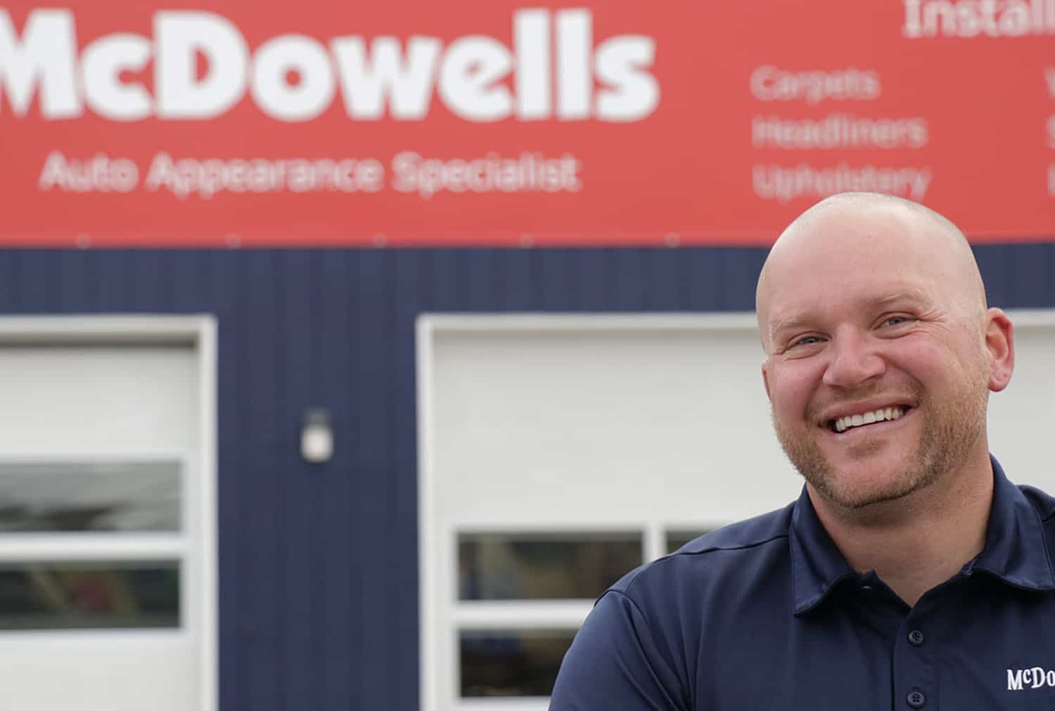 There's a picture of Matt, the Front Office Manager. He's standing in front of McDowell's building.
