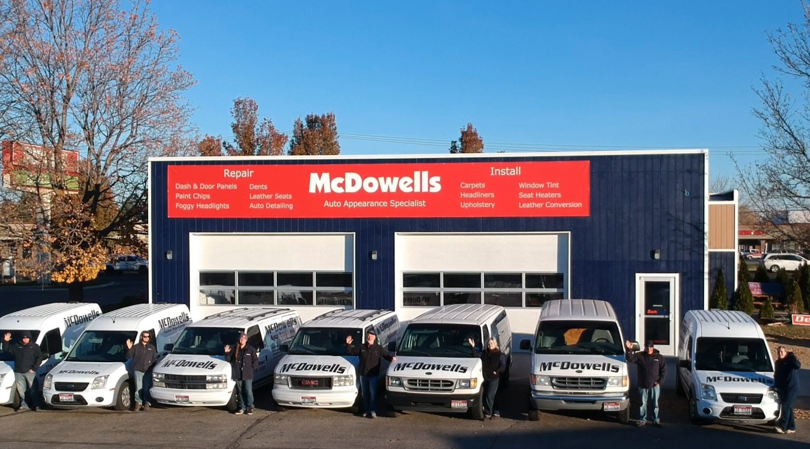 There is a faraway shot of the McDowells building with multiple vans parked in the front. 